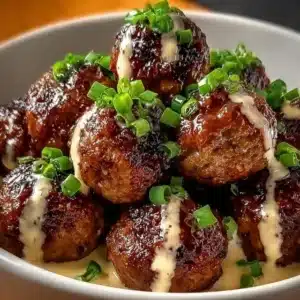 Plate of Korean BBQ meatballs with garnishes and sauce