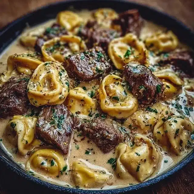 Cracked Garlic Steak Tortellini in creamy sauce, garnished and ready to serve.